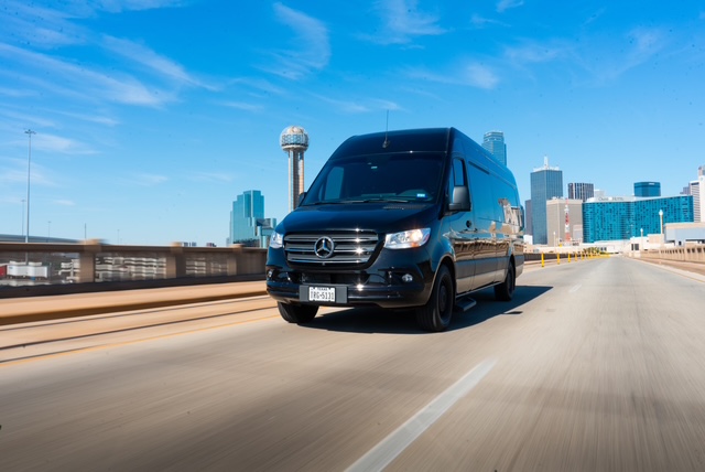 Sprinter on the highway with Dallas skyline