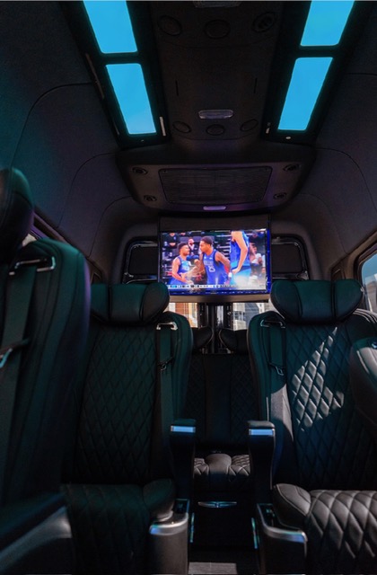Captain chairs facing a big-screen TV under a panoramic roof